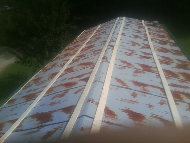 Rusted metal roof panels with new wood purlins before replacement — Storm Damage Roof Repair in Emerson by Roofing Brothers